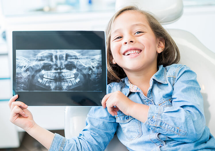 Young girl holding her dental X-rays