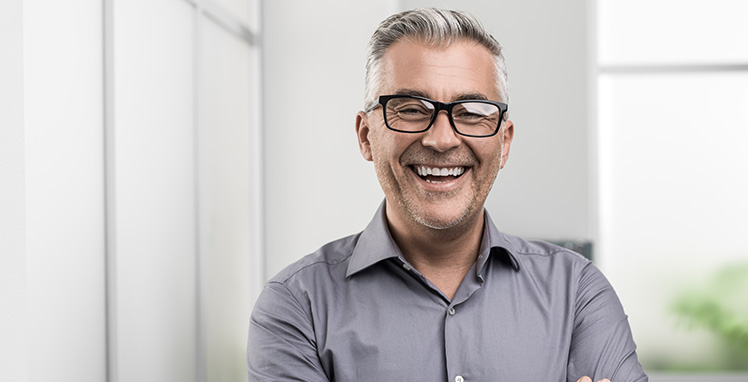 Older man smiling wearing glasses