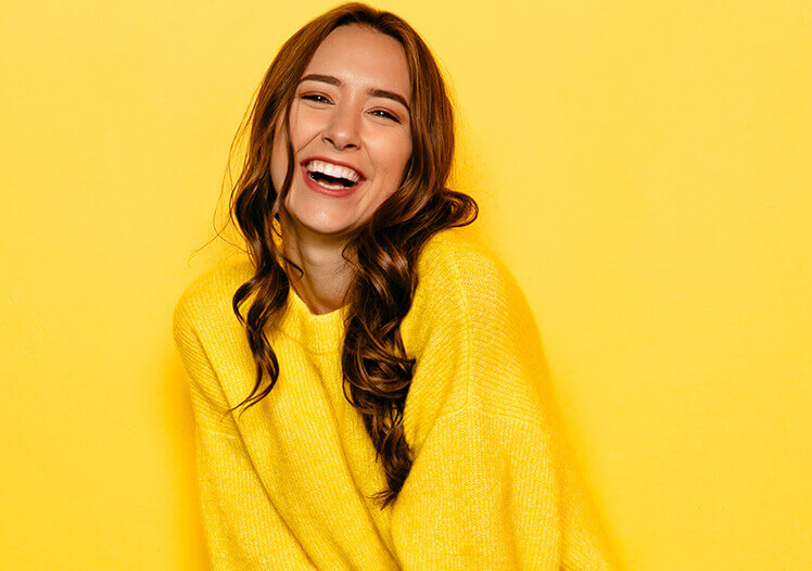 Girl smiling with a yellow background