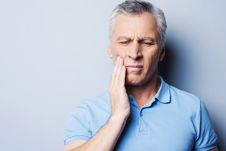 man holding his jaw in pain