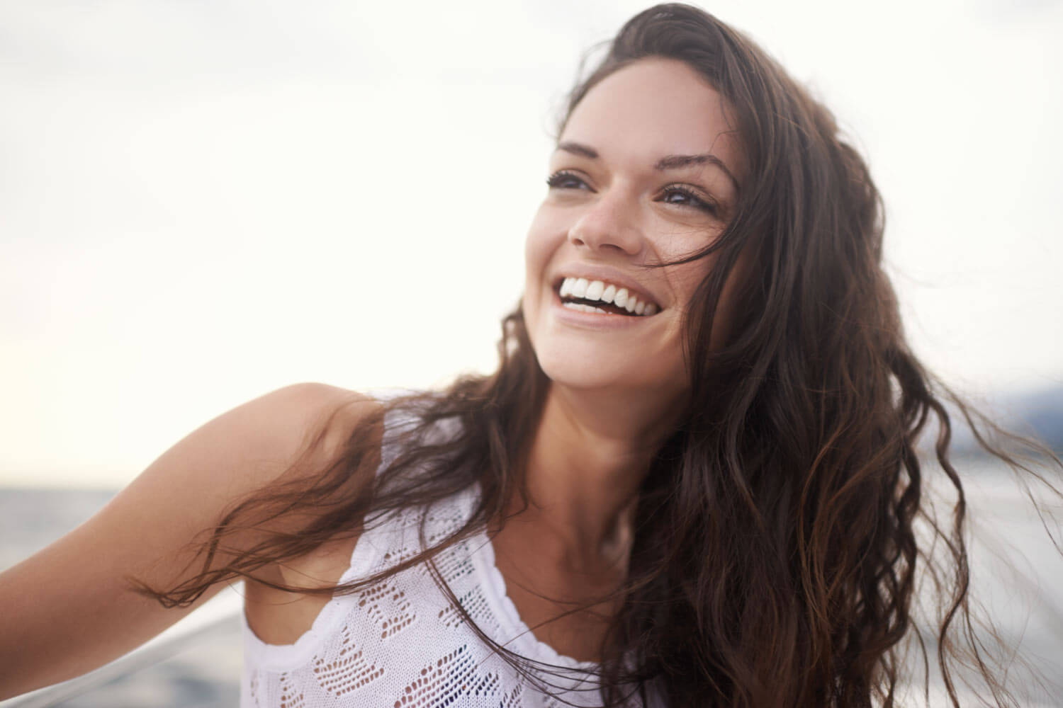 Brunette woman smiles after getting cosmetic dentistry in Wolcott, CT