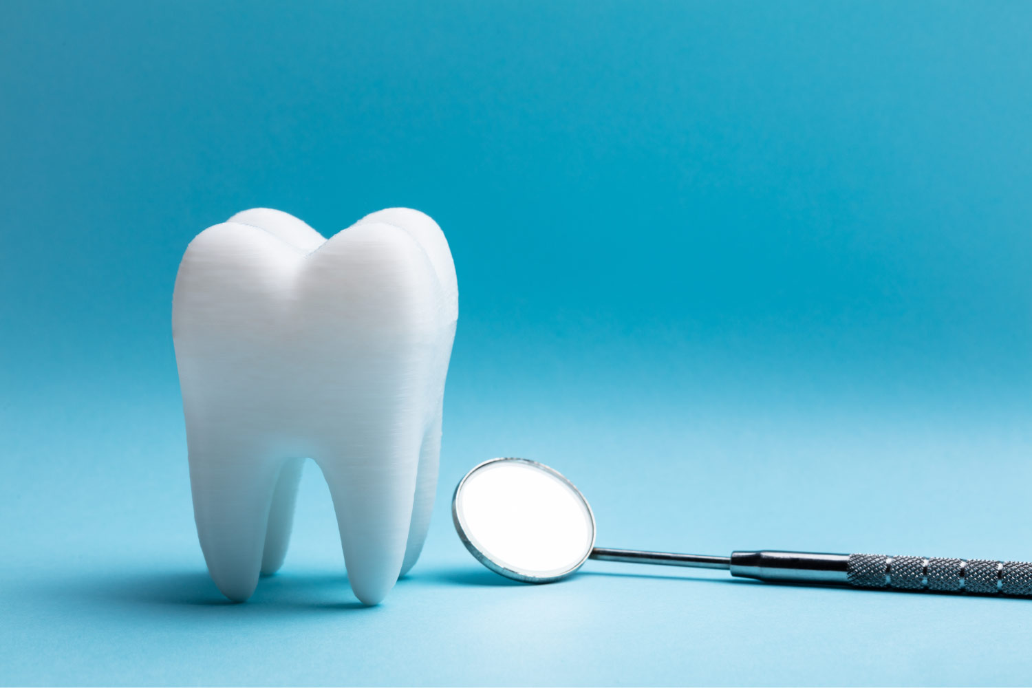 Closeup of a tooth extraction next to a special dental mirror in Wolcott,CT