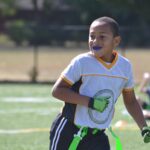 Young boy playing flag football wears a custom sports mouthguard