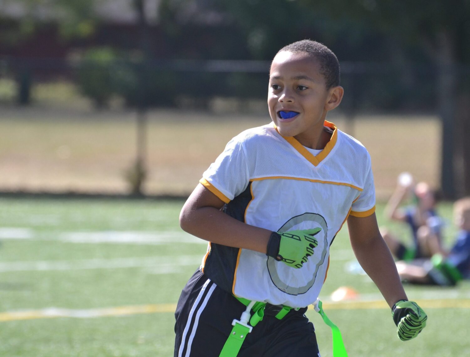 Young boy playing flag football wears a custom sports mouthguard