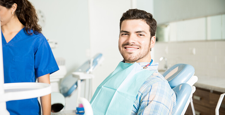 smiling man sitting in a dental chair