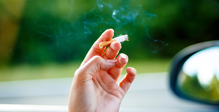 closeup of a person's hand holding a cigarette