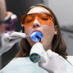 Image of woman in dental chair receiving a preventive oral cancer screening with a specialized light.