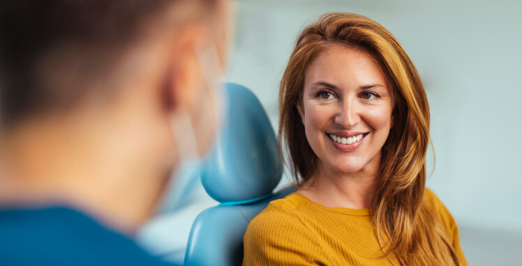 smiling woman talking with her dentist